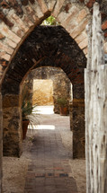 brick walkway under brick arches 