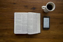 open Bible, cellphone, and coffee mug on a table 