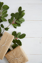 holly and gifts on a white wood background 
