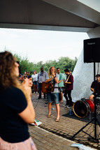 musicians on stage at an outdoor worship service 