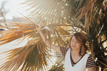 a woman holding on to a palm tree