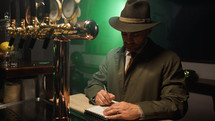 Detective with hat write on notebook