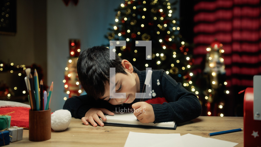 Kid writing letter to Santa Clause On Table