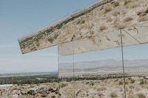 reflection of desert landscape in mirrored glass 