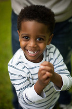 toddler boy smiling with praying hands 