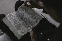 A man sitting and reading a Bible.