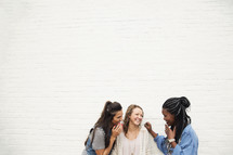 Three young women laughing together.