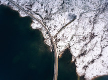 aerial view over highway hugging a shoreline 