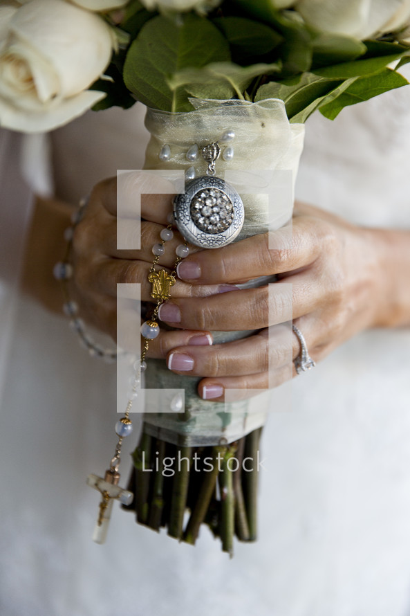 bride holding a bouquet and a rosary