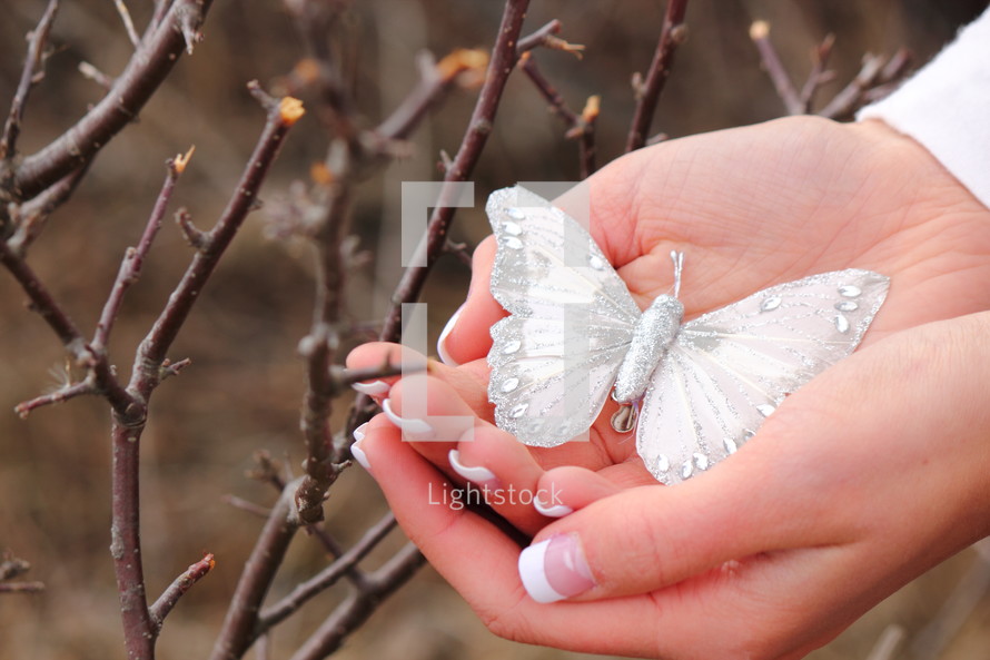 woman holding a decorative white butterfly 
