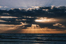 rays of sunlight through clouds over the ocean 