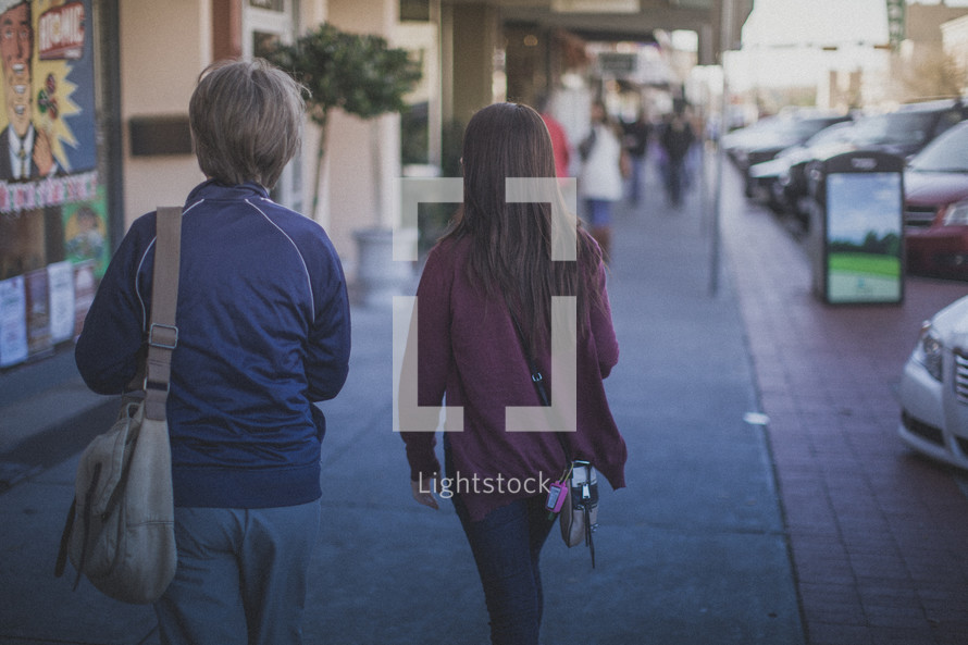 Two woman walking down the sidewalk