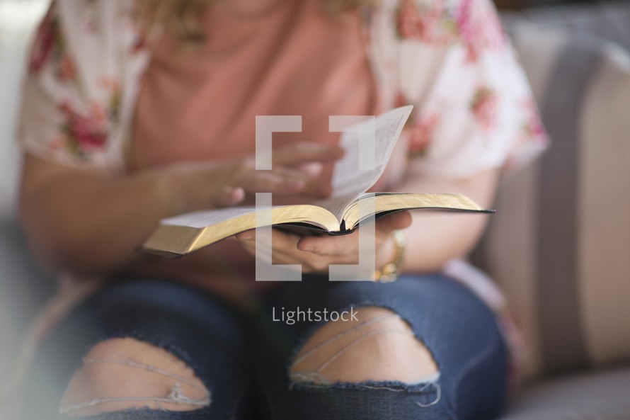 a woman flipping the page of a Bible.