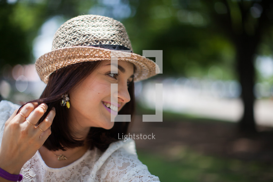 brunette woman in a straw hat outdoors 