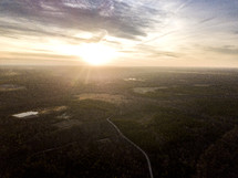 aerial view over a lake and forest at sunset 