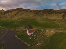 aerial view over a red roof church and cemetery 