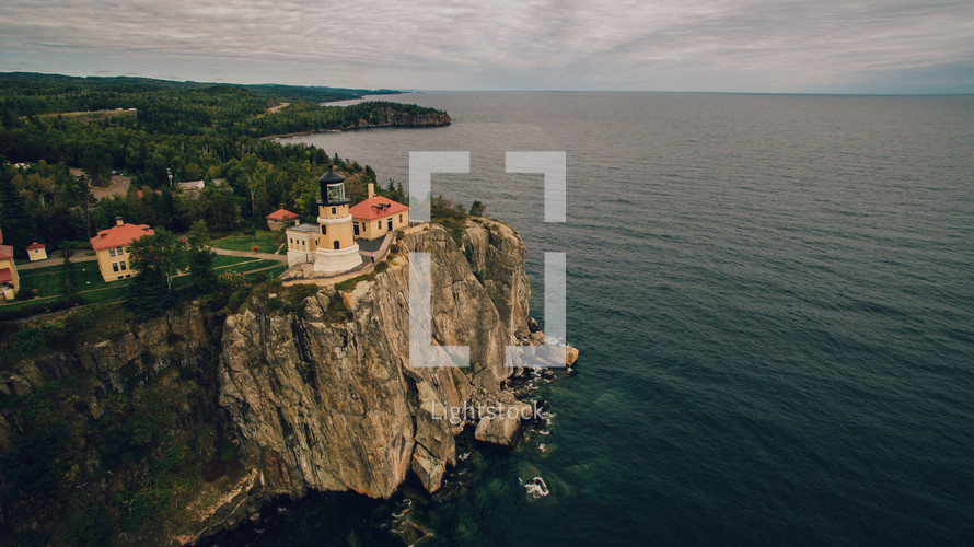 lighthouse on the edge of a cliff along a shoreline 