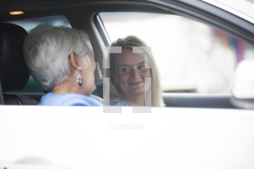 mother and daughter in a conversation while riding in a car 