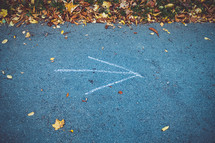 arrow drawn on a paved path
