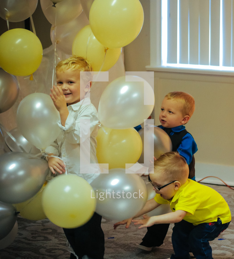 toddlers playing with helium balloons 