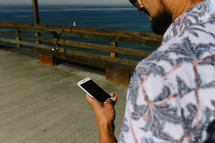 a man on a pier looking at his cellphone