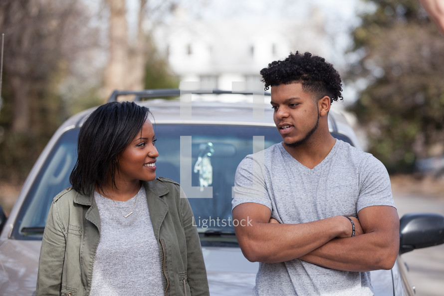 couple talking in front of a car 