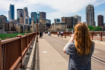 woman taking a picture of a city view 