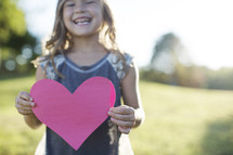 a child holding a paper heart 