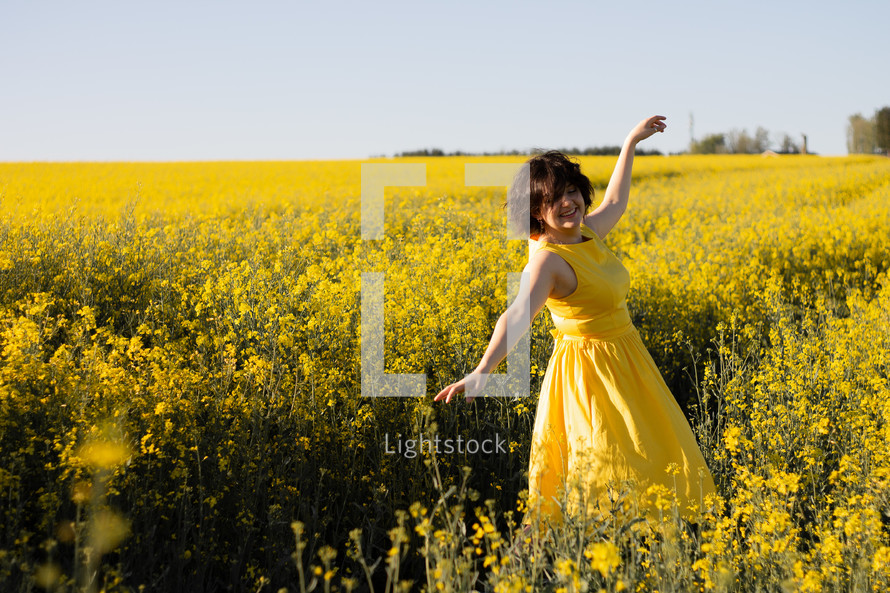 Girl dancing in a yellow field of flowers