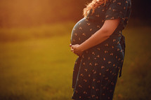 Silhouette of a pregnant woman in a beautiful dress on a light background.