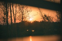 view of the orange sky at sunset through a window 