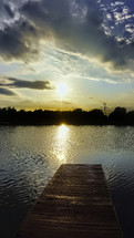 a dock at sunset over a lake 