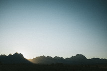 sunrise behind mountain peaks 