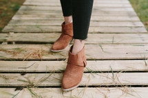 woman in boots on a boardwalk 