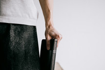 a man standing holding a Bible at his side 