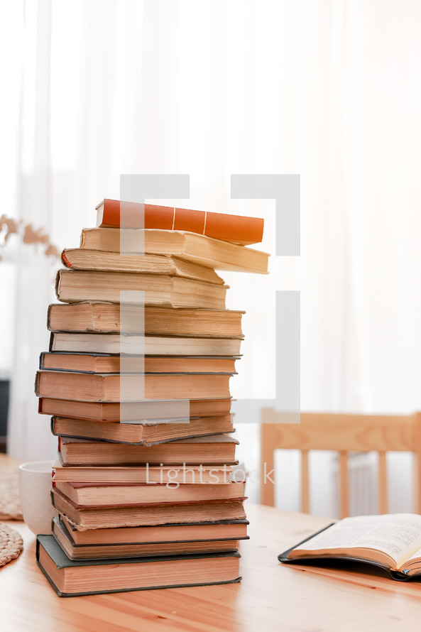 Stack books or textbooks and one opened book on wooden desk in room. Literature research. Concept - information search in books. Back to school. Education and school concept. copy space