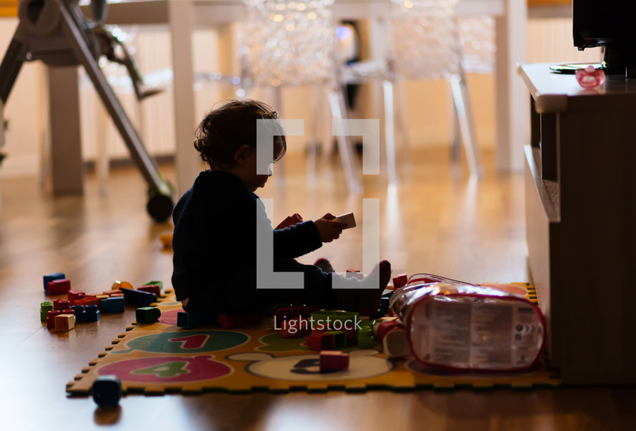 infant girl playing with toys at home 