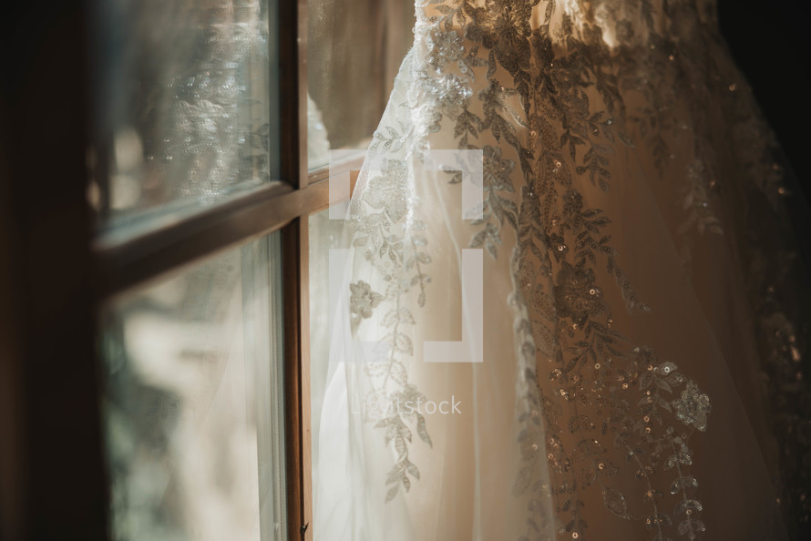 a wedding dress leaning against a window