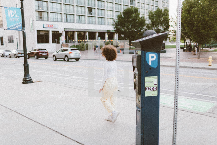 woman walking past a parking meter 