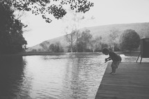 a toddler boy fishing on a dock 