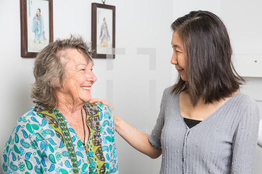 a healthcare professional talking with an elderly woman in a doctors office 