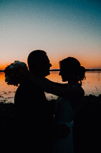 silhouette of a bride and groom at sunset 