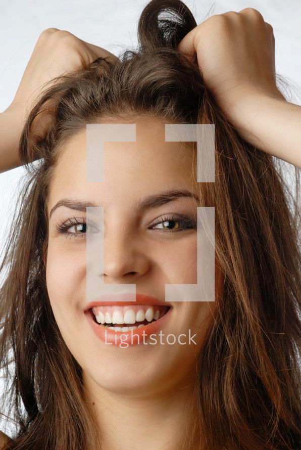 Smiling young woman with hand on her hair