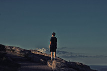 a boy standing on a mountaintop 