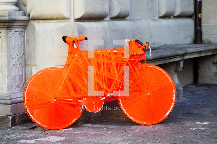 bicycle wrapped in orange string 