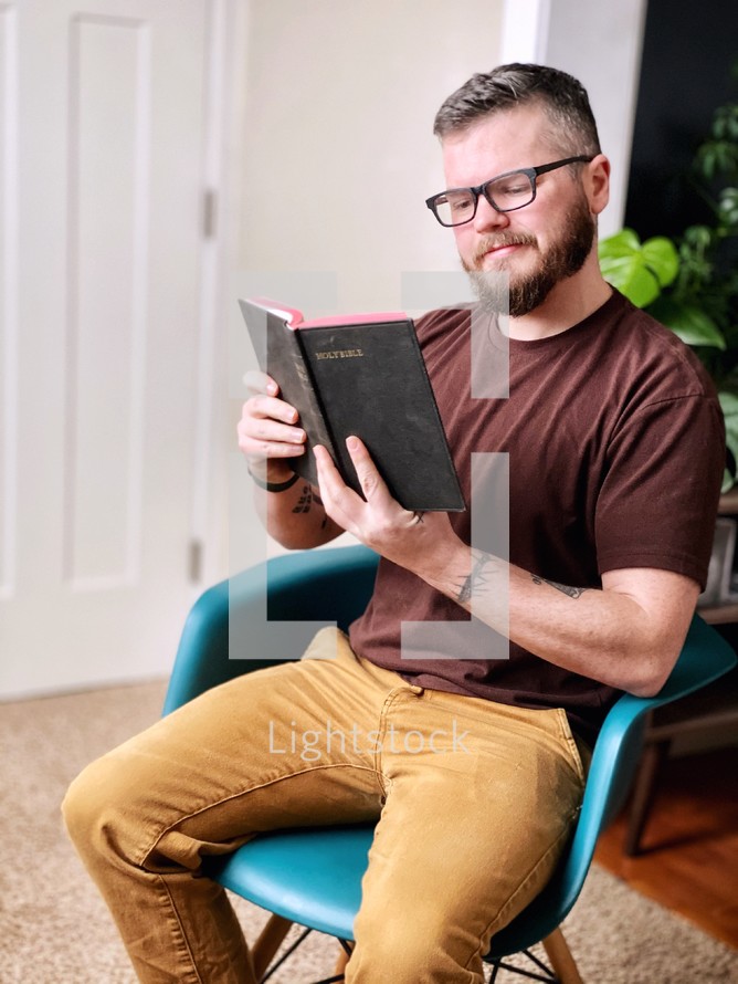 a man sitting reading the Bible 
