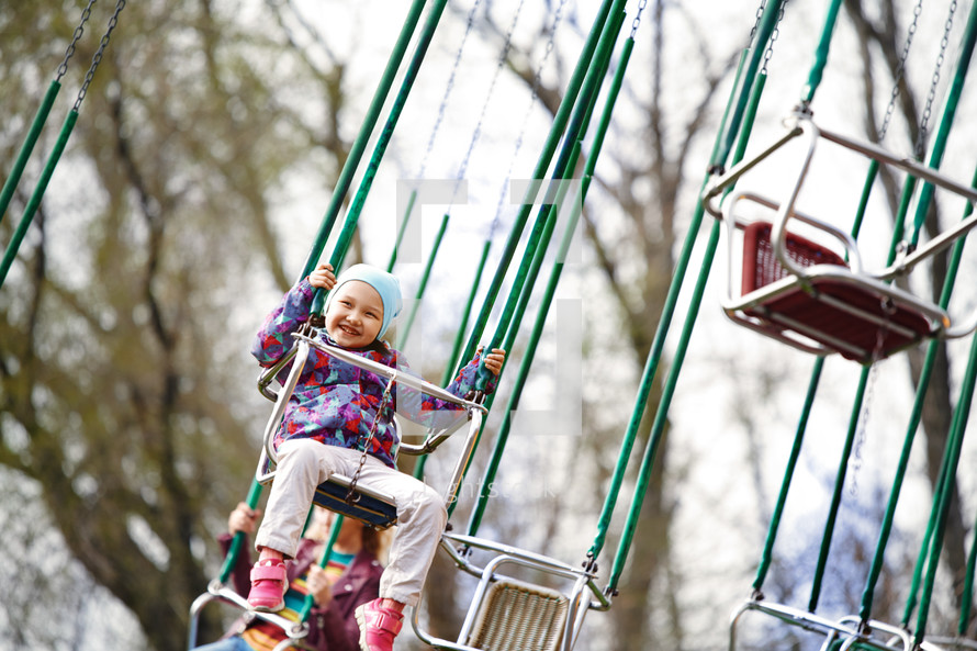 a child on swinging chairs ride at a fair 