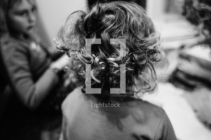 the back of a little boys head with curly hair 