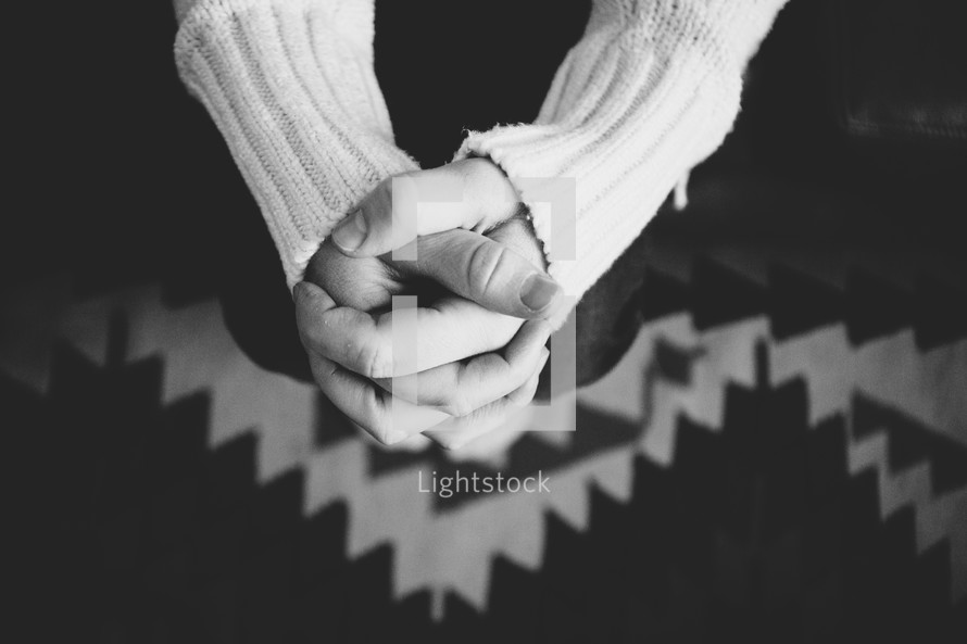A woman's hands clasped t together.
