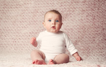 infant girl on a pink rug 
